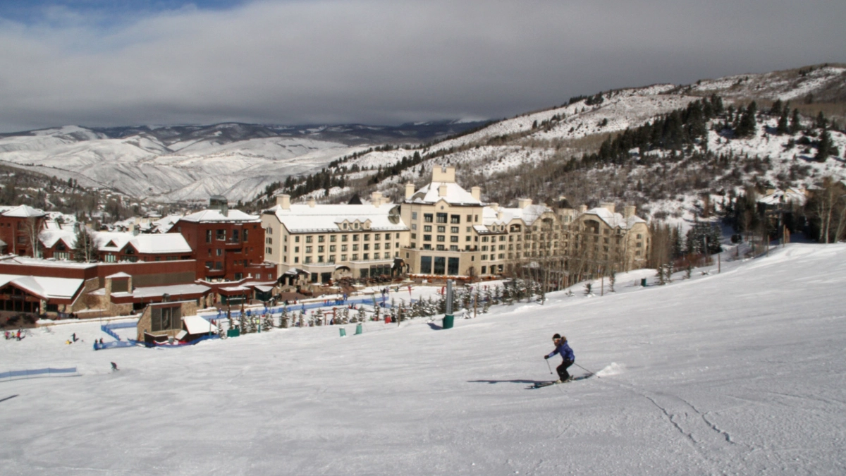 Luxury black SUV approaching Beaver Creek through a scenic Colorado mountain landscape